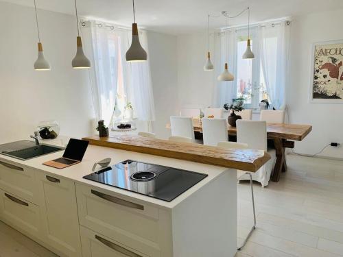 a kitchen with a table with a laptop on it at Villa di Design con Giardino e Spa in Cittá in Cuneo