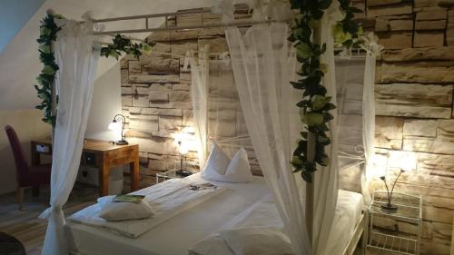 a bedroom with a canopy bed with white curtains at Best Western Hotel Rosenau in Bad Nauheim