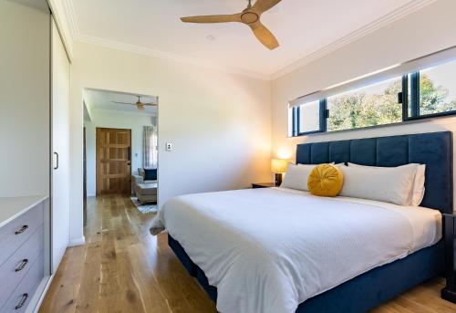 um quarto com uma cama grande e uma janela grande em Lilly Pilly Cottage Margaret River em Margaret River