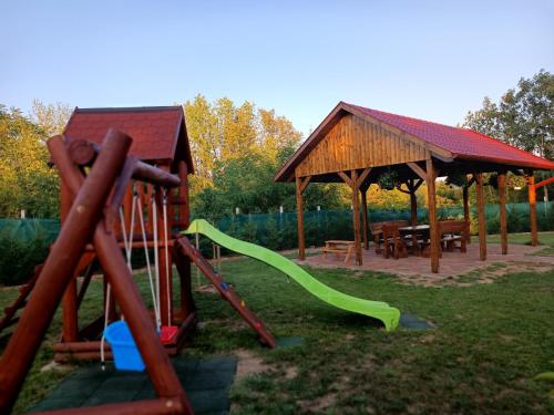 a playground with a slide and a gazebo at Strand Vendégház in Poroszló