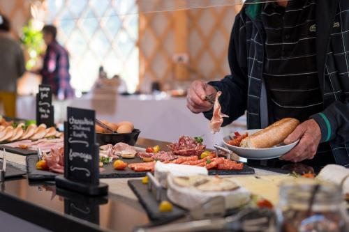 a man is preparing food on a buffet table at Domaine Mélusine - à 2km du Puy duFou France ! in Les Épesses