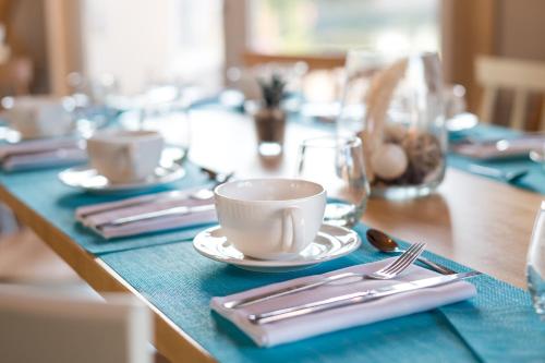 a table with plates and cups and silverware on it at Domaine Mélusine - à 2km du Puy duFou France ! in Les Épesses