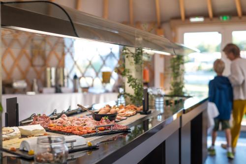 a child standing in front of a buffet line with food at Domaine Mélusine - à 2km du Puy duFou France ! in Les Épesses