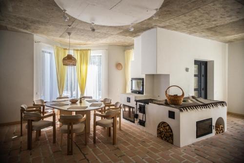 eine Küche und ein Esszimmer mit einem Tisch und einem Kamin in der Unterkunft Grand Villla Skyta in Worochta