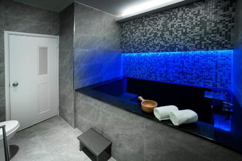 礁溪鄉的住宿－福岡2號溫泉會館，蓝色瓷砖浴室设有卫生间和水槽