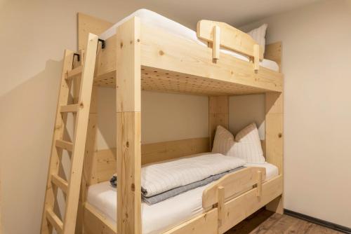 Etagenbett in einem kleinen Zimmer mit Leiter in der Unterkunft Villa Lara Föhre in Kastelruth