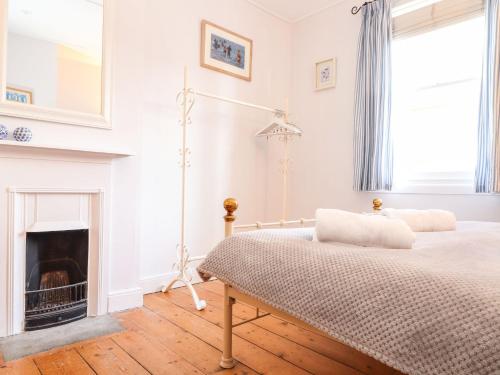 a bedroom with a bed and a fireplace at 2 Chapel Place in Mousehole