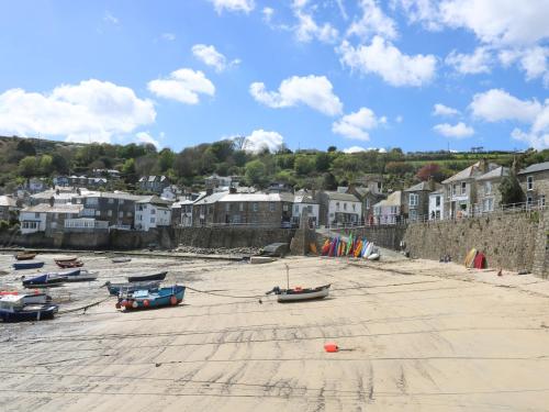 a group of boats sitting on the sand on a beach at 2 Chapel Place in Mousehole