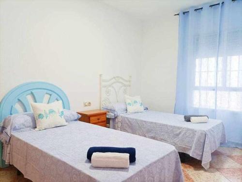 a bedroom with two beds and a window at Apartamento Vista a la Isla in Carboneras