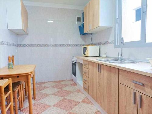 a small kitchen with a sink and a table at Apartamento Vista a la Isla in Carboneras