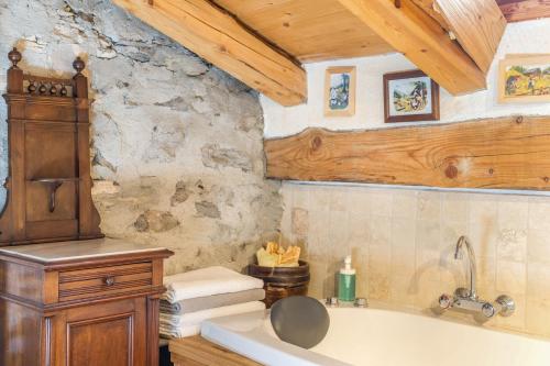 uma casa de banho com uma banheira e uma parede de pedra em Arpy an em Morgex