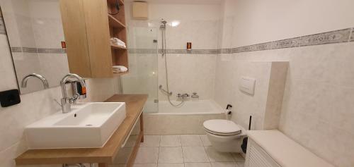 een badkamer met een wastafel, een toilet en een bad bij Fewo-Suite "Horizonte I"mit Boot in Ascheberg