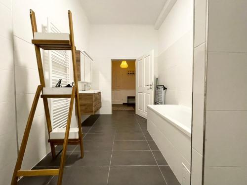 uma casa de banho com uma escada, uma banheira e um lavatório. em Premium Apartment located at the famous Vienna Kutschkermarkt em Viena