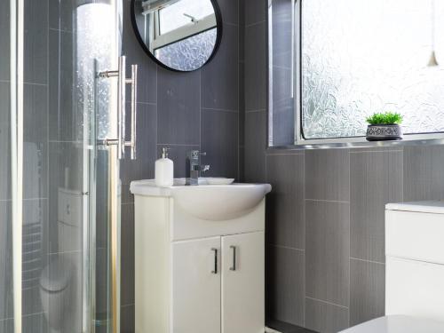 uma casa de banho com um lavatório branco e um espelho. em Lily Apartment 2-Remarkable 2 Bed Bedlington em Bedlington