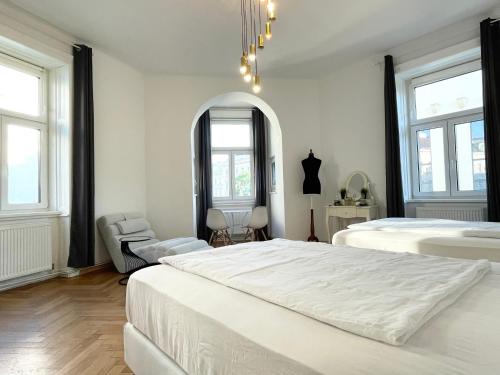 um quarto branco com 2 camas e uma cadeira em Premium Apartment located at the famous Vienna Kutschkermarkt em Viena