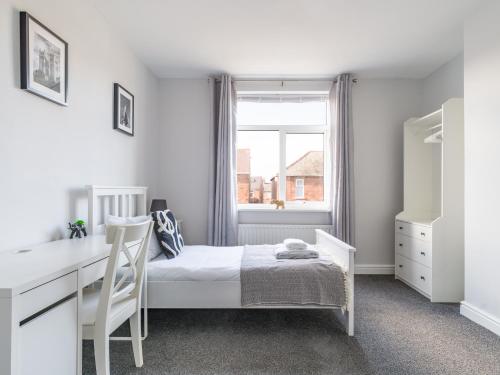 a bedroom with a bed and a desk and a window at Lily Apartment 2-Remarkable 2 Bed Bedlington in Bedlington