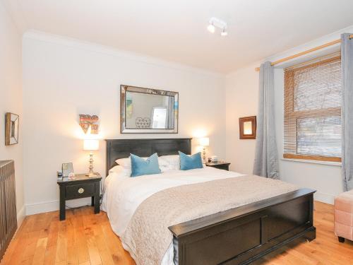 a bedroom with a large bed with blue pillows at Sea View in St Austell