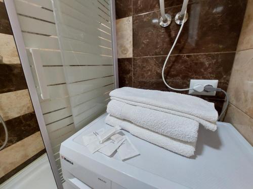 een badkamer met een douche en een witte handdoek bij Стильні апартаменти Кравчука 10 LutskDoba in Loetsk