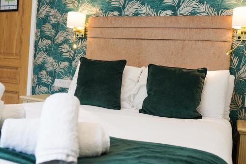 a bedroom with a bed with green and white pillows at Gwydyr Hotel in Betws-y-coed