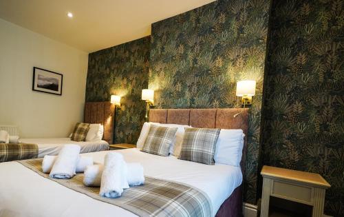 a hotel room with two beds with towels on them at Gwydyr Hotel in Betws-y-coed