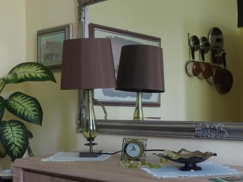 a table with two lamps and a clock on it at Apartment Baroque in Belgrade