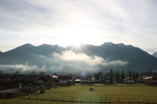 a view of a mountain with the sun poking through the clouds at Gasthof & Hotel Zur Post in Wallgau