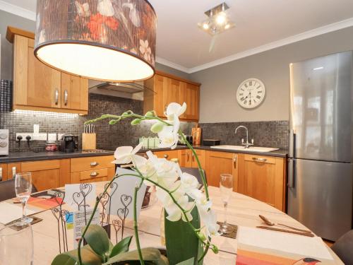 a kitchen with a dining table with a light fixture at Hillcroft in St Austell