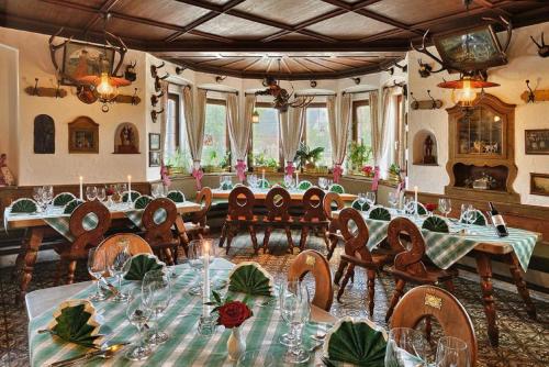 a large dining room with tables and chairs and windows at Gasthof & Hotel Zur Post in Wallgau