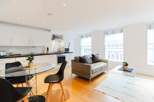 a kitchen and living room with a couch and a table at Covent Garden by Excel Apartments in London