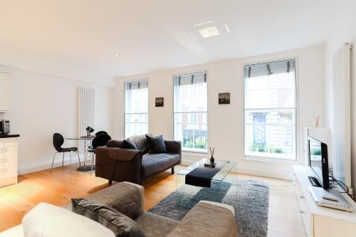 a living room with a couch and a tv at Covent Garden by Excel Apartments in London