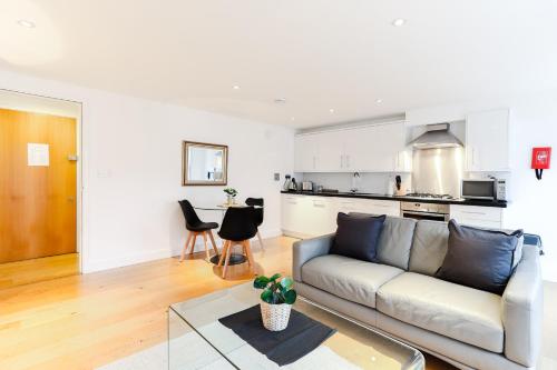 a living room with a couch and a kitchen at Covent Garden by Excel Apartments in London