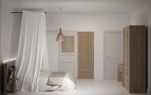 a white bedroom with a bed and a curtain at Leo SereneS Hotel in Alacati