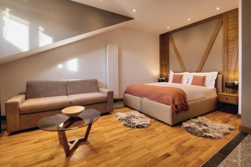 a bedroom with a bed and a couch and a table at MODERN MOUNTAIN II in Kolašin