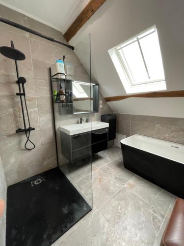 a bathroom with a sink and a bath tub at Domaine de La Vove - Maison d'hôtes classée, cadre paisible et naturel - ambiance insolite jardin paysager doté d'une terrasse spacieuse - une vue panoramique exceptionnelle -authenticité et élégance in Corbon
