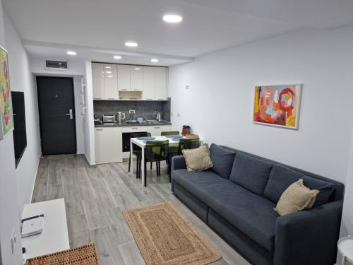 a living room with a blue couch and a kitchen at OLIMP Sea View Apartments - The Sunny Apartment in Olimp