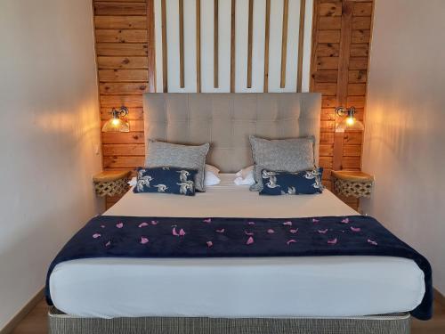 a bedroom with a large bed with blue and purple sheets at Hôtel Hamaha Beach in Mamoudzou