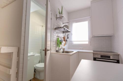 a white bathroom with a sink and a toilet at De El Retiro al cielo in Madrid