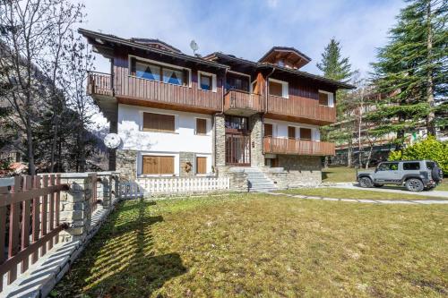 a house with a fence in front of a yard at In centro a Courmayeur Mont Blanc in Courmayeur
