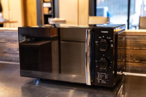 a microwave oven sitting on top of a counter at 173 ON THE ISLAND enoshima private villa 江の島仲見世通り徒歩3分にある1日1組限定の貸切別荘 in Fujisawa