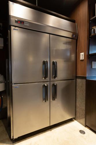 a large stainless steel refrigerator in a kitchen at 173 ON THE ISLAND enoshima private villa 江の島仲見世通り徒歩3分にある1日1組限定の貸切別荘 in Fujisawa