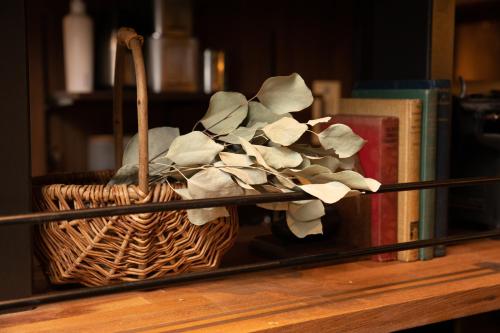 a wicker basket sitting on a table with books at 173 ON THE ISLAND enoshima private villa 江の島仲見世通り徒歩3分にある1日1組限定の貸切別荘 in Fujisawa