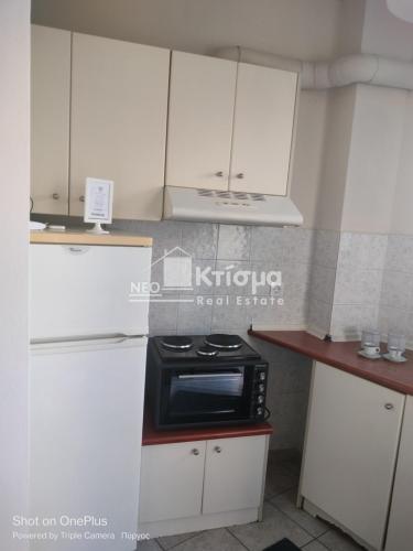 a kitchen with white cabinets and a black microwave at Sweet studio in Pyrgos city near Olympia in Pýrgos
