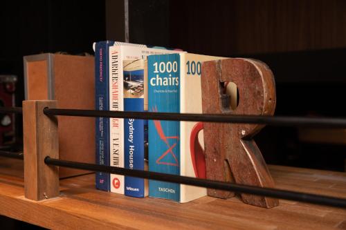 a bunch of books sitting on top of a shelf at 173 ON THE ISLAND enoshima private villa 江の島仲見世通り徒歩3分にある1日1組限定の貸切別荘 in Fujisawa