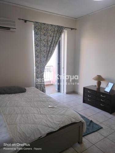a bedroom with a bed and a dresser and a window at Sweet studio in Pyrgos city near Olympia in Pýrgos