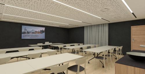 uma sala de conferências com mesas e cadeiras e um ecrã em Hotel Petersboden em Lech am Arlberg
