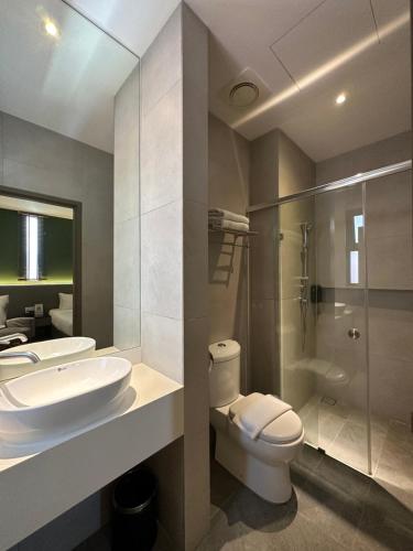 La salle de bains est pourvue d'un lavabo, de toilettes et d'une douche. dans l'établissement The Gallivant Hotel, à George Town