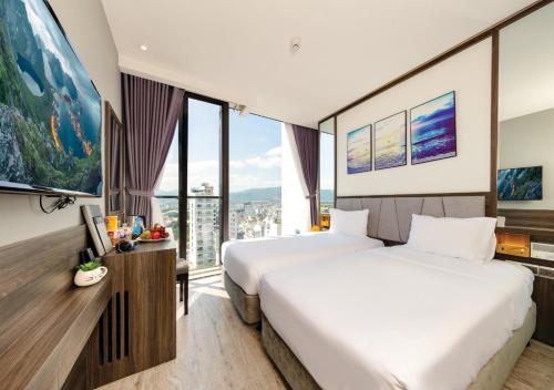 a hotel room with two beds and a large window at Ivy Hotel Nha Trang in Nha Trang