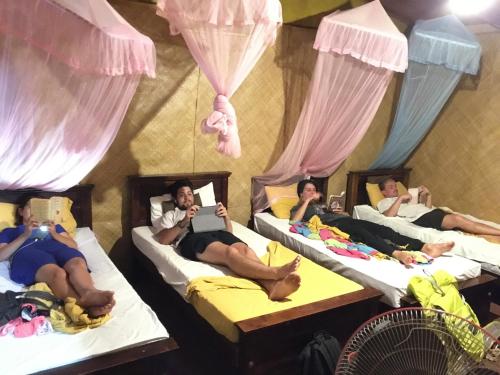 a group of people laying on beds in a room at Tree house Hostel Sigiriya in Sigiriya