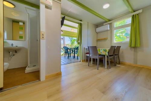 a kitchen and dining room with a table and chairs at Glamping -Bungalows El Faro in Conil de la Frontera