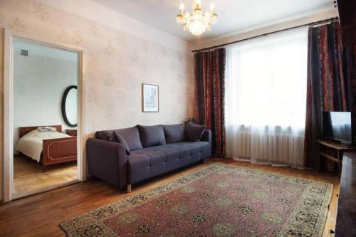 a living room with a couch and a mirror at City Center Huge 3-Bedroom Apartment in Tallinn